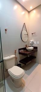 a bathroom with a toilet and a sink and a mirror at Chalé Vertente da Canastra in São Roque de Minas +29 photos