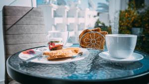 a table with a plate of food and a cup of coffee at Midtown Napa Apartments in Ayia Napa
