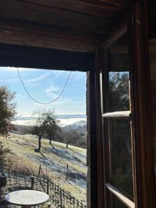 a window with a view of a field and a table at Lacouty le paradis! in Junhac