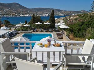 a table with food on it next to a pool at Akrotiri Hotel in Parikia