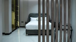 a bedroom with a bed with white sheets and a mirror at ارتاما بوتيك للشقق المخدومة in Riyadh