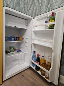 an open refrigerator filled with bottles and drinks at Mountain View Amza Accomodation in Râşnov