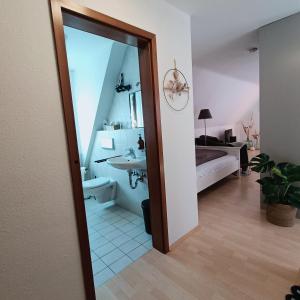 a room with a bathroom with a sink and a bed at Urban Apple in Bad Mergentheim