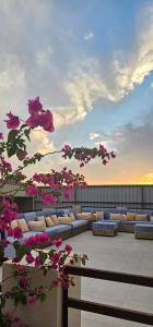a patio with couches and pink flowers on a building at Al Barari Farm & Resorts Al Ain in ‘Ayn al Fayḑah