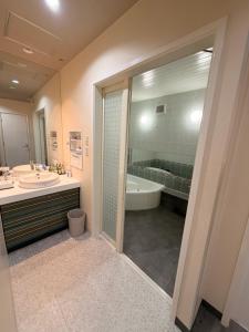 a bathroom with a tub and a sink and a shower at ホテルメイプル in Odate +23 photos