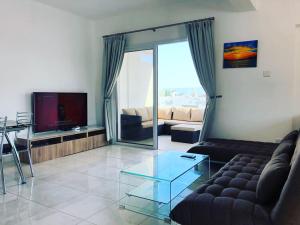 a living room with a couch and a glass table at Midtown Napa Apartments in Ayia Napa