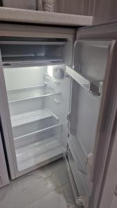 an empty refrigerator with its door open in a kitchen at Dostoievski 4 in Bălţi