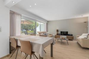 a white living room with a table and a couch at Parkhouse C0 in De Haan