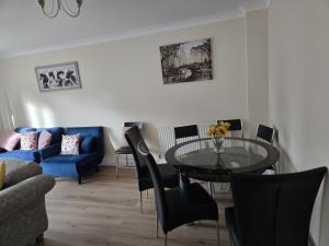 a living room with a glass table and chairs at The Flexible Lodge-Ashford in Kingsnorth +12 photos