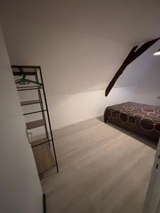 a bedroom with a bed and a ladder in a room at Appartement Numéro 3, centre chateau-renault in Château-Renault