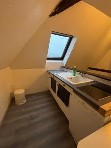 an attic kitchen with a sink and a window at Appartement Numéro 3, centre chateau-renault in Château-Renault