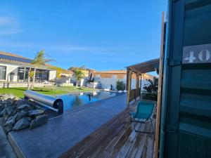 a house with a deck and a swimming pool at Studio Conteneur in Cruscades