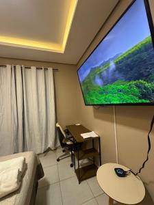 a room with a large projection screen on the wall at Conforto - Casa completa com ar-cond - Wi-Fi in Trindade