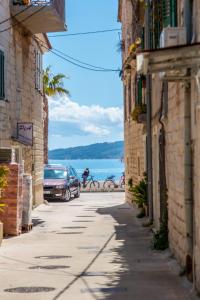 a street with buildings and a person riding a bike at Studio apartman Relota in Kaštela