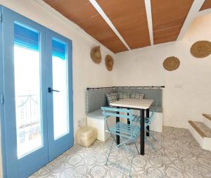 a dining room with a table and a blue door at Casa el far Peñíscola in Peniscola +20 photos