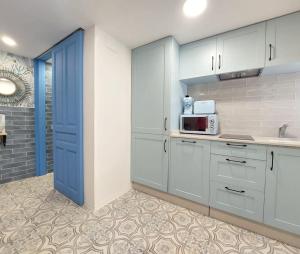 a kitchen with white cabinets and a blue door at Casa el far Peñíscola in Peniscola