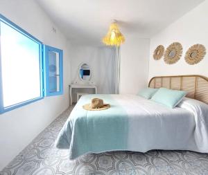 a bedroom with a bed with a hat on it at Casa el far Peñíscola in Peniscola