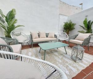 a patio with chairs and tables and a couch at Casa el far Peñíscola in Peniscola