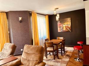 a living room with a table and chairs at Tranquille Homestay near JKIA Airport & SGR Station Nairobi in Nairobi +21 photos