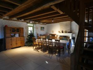 a kitchen and dining room with a table and chairs at Domaine de La Maison d'Aum in Bourrou