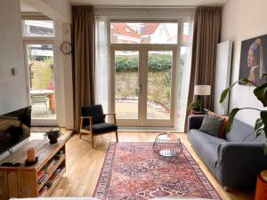 a living room with a couch and a tv at Apartment Havenstraat in Delft +27 photos