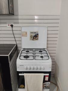 a white stove in a kitchen with a towel at Cozy studio at Kisimani Heights Apartment Mombasa in Mombasa