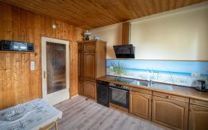 a kitchen with wooden cabinets and a sink at Gästehaus Barthel in Gosen