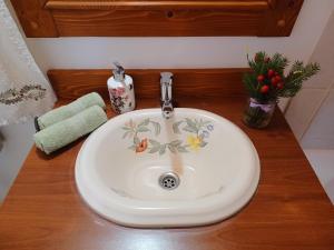 a bathroom sink with a flower design on it at Fenyő Kuckó in Bodony +30 photos