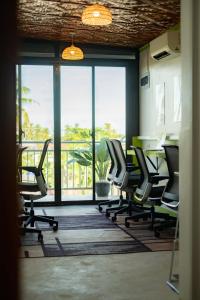 an office with chairs and a table and a large window at Matropica CoWorking Hostel in General Luna