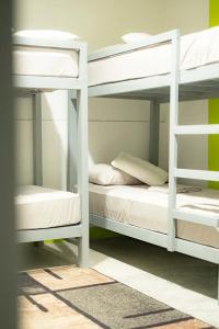 two white bunk beds in a room with at Matropica CoWorking Hostel in General Luna +7 photos