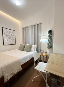 a bedroom with a bed and a table and a chair at Matropica CoWorking Hostel in General Luna