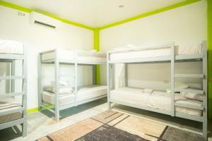 a room with three bunk beds in it at Matropica CoWorking Hostel in General Luna