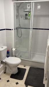 a white bathroom with a shower and a toilet at 2 bed room , ensuite Flat close to Heathrow, Windsor , Langley in Langley Marish