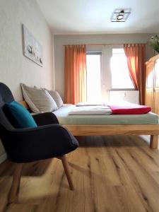 a bedroom with a bed and a chair in it at Ferienwohnung Gessert in Querfurt