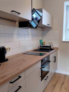 a kitchen with white cabinets and a wooden counter top at Ferienwohnung Gessert in Querfurt