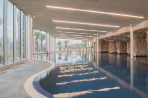 a swimming pool with water in a building at Mjus Resort & Thermal Park in Körmend