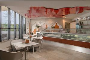 a restaurant with tables and chairs and red chandeliers at Mjus Resort & Thermal Park in Körmend