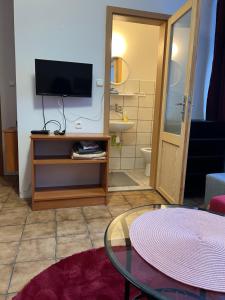 a living room with a tv and a table at Pokoje in Duszniki Zdrój