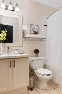 a white bathroom with a toilet and a sink at Condo Loft at Blue Mountain in Blue Mountains