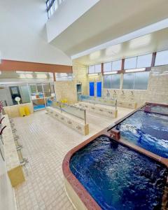 a large indoor swimming pool in a large building at Kunark KM102 Stay in Kokubunji