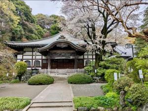an asian style building with a gate in a garden at Kunark KM102 Stay in Kokubunji