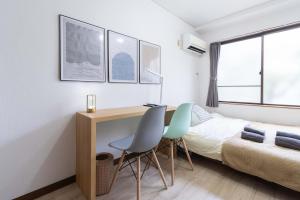a bedroom with a bed and a desk and chairs at Kunark KM102 Stay in Kokubunji +58 photos