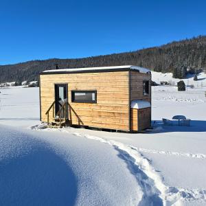 a wooden cabin in the snow in the snow at La cachette du Jura in Bois-dʼAmont