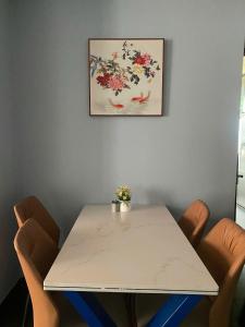 a white table with chairs and a picture on the wall at Blue Luxury Hotel & Spa in Danang