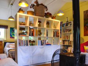 a room with a book shelf filled with books at Owls Nest in Stradbroke