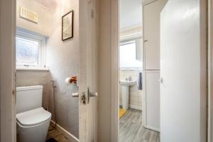 a bathroom with a toilet and a sink at Spacious 4-Bed House, & Prime Location Solihull in Olton +31 photos