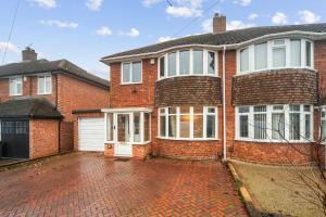 a red brick house with a white garage at Spacious 4-Bed House, & Prime Location Solihull in Olton