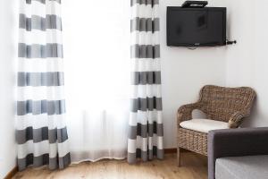 a living room with a chair and a television at Fiszer 1 & 2 in Sopot