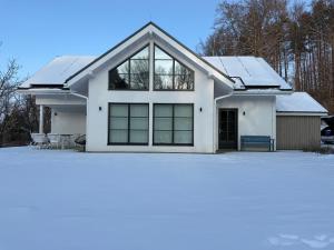 a white house with snow on the roof at Anešinka in Černá Voda