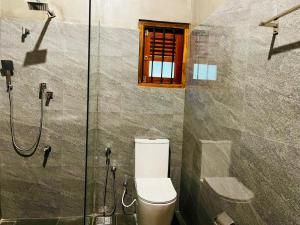 a bathroom with a toilet and a glass shower at Villa Stillrock in Dodanduwa